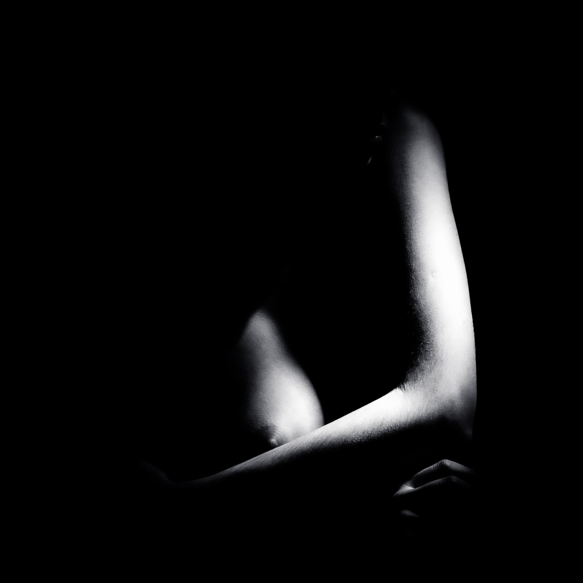minimal black and white fine art photograph with a single illuminated edge emerging from darkness