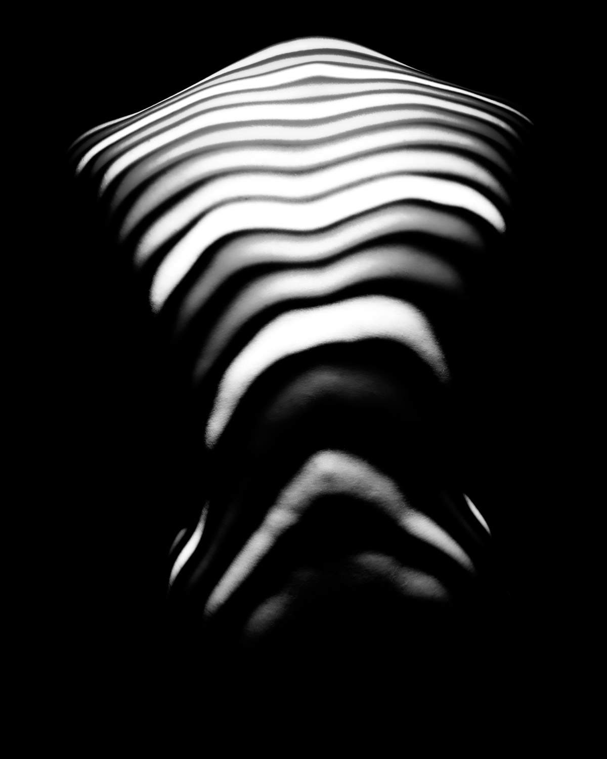 minimal projection pattern creating structured contours across an anonymous sculpted volume